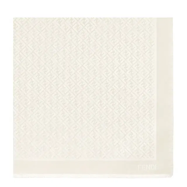 The iconic shawl is made of an ivory wool and organic The iconic shawl is made of an ivory wool and organic